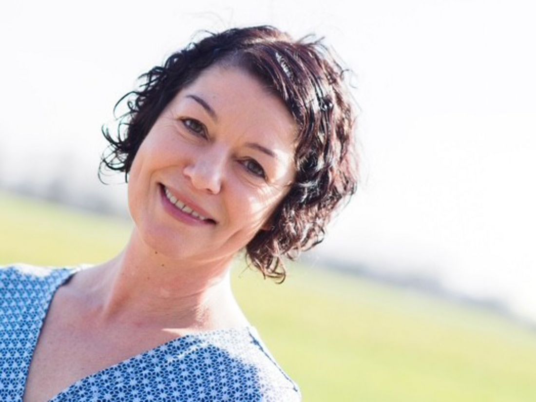 Portrait von Alexandra Czenia-Kunz, die kurze lockige Haare hat und freundlich in die Kamera lächelt.