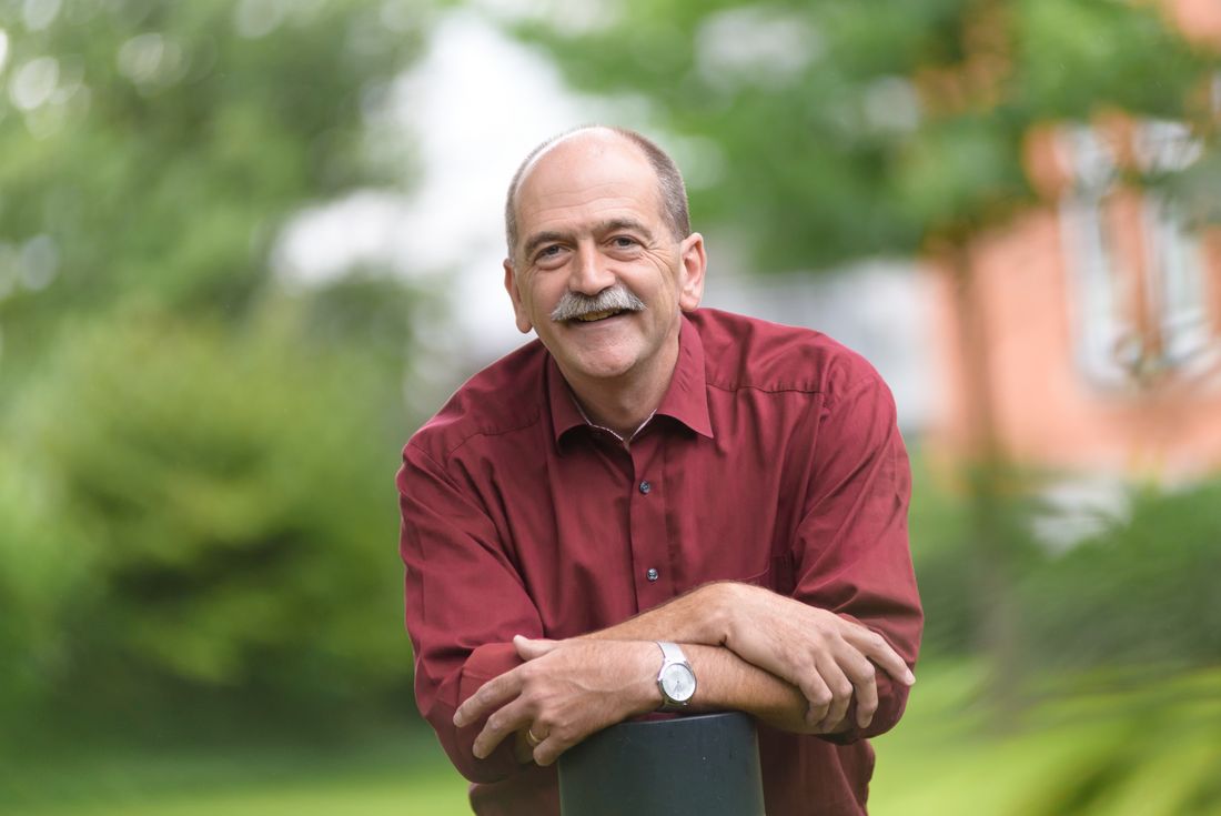 Portrait von Dietmar Redeker, der in lässiger Pose in die Kamera schaut und lächelt.