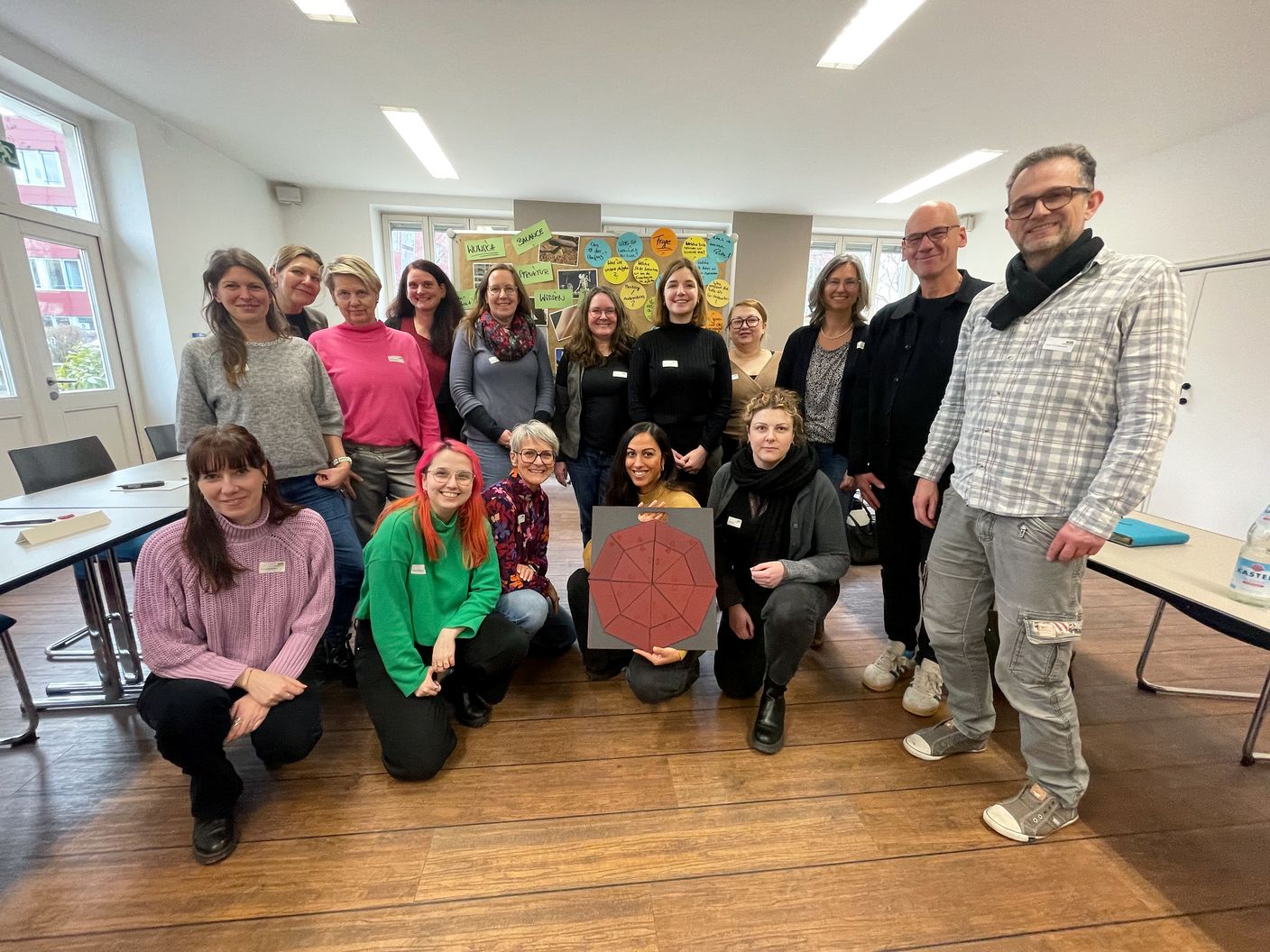 Eine diverse Gruppe von Menschen posiert für ein Gruppenfoto.